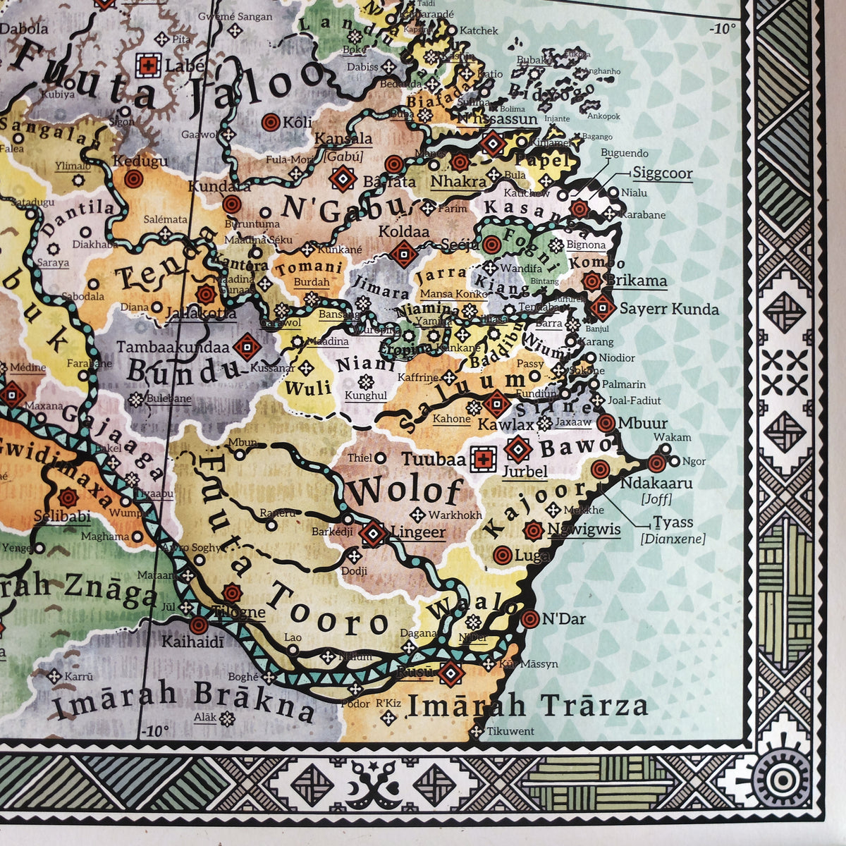Detailed Senegambia cartography on the Alkebu-Lan map showing the Wolof Empire, Fuuta Tooro, Fulani jihad states, and N'Gabu (Kaabu). Highlights the fishing villages of Ndakaaru and Joff (Lebou Republic) that later merged into modern Dakar, as well as the nine historic Mandinka Mande kingdoms (including Kombo, Niani, Wuli, Baddibu, and Kantora) painstakingly mapped along the Gambia River, all framed by traditional geometric corner borders by Nikolaj Jesper Cyon.