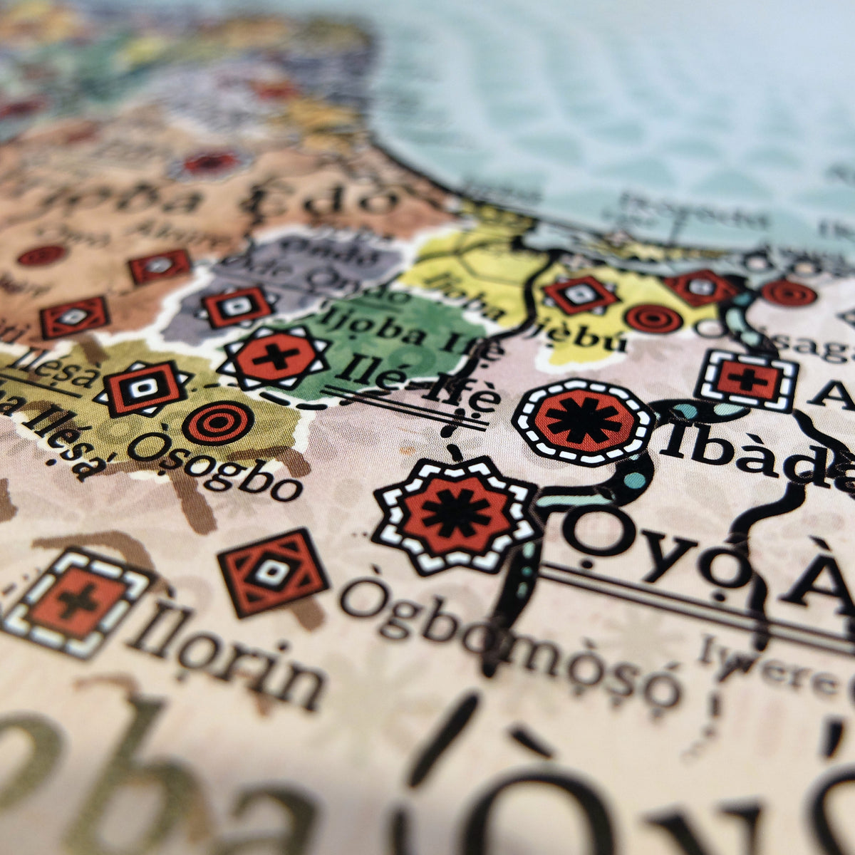 Detailed macro photograph of Yorubaland in southwestern Nigeria on the Alkebu-Lan map print. Captures the spiritual center of Ilé-Ifẹ̀, world-renowned for its 12th–15th century naturalistic bronze, brass, and terracotta sculptures; Ìbàdàn, the military stronghold of the 19th-century Kiriji War (1877–1893); and Òyọ́ Àjàká, the relocated capital of the cavalry-powered Oyo Empire following the fall of Oyo-Ilé. Also features key Yoruba kingdoms, city-states, and regional centers including Òṣogbo, Ìlorin, Ìjeṣà,