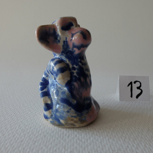 Handcrafted ceramic monkey figurine "The Blue & White Monkey (#13)" in stoneware by Nikolaj Jesper Cyon. Features a seated monkey looking upwards, decorated with intricate cobalt blue and dark patterns over a light, speckled cream and pinkish base, with a glossy glaze finish.