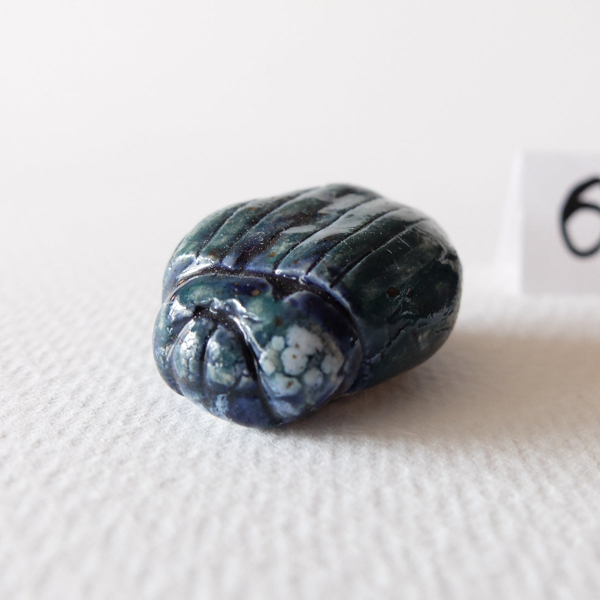 Handcrafted ceramic beetle figurine "The Jade Scarab (#6)" in stoneware by Nikolaj Jesper Cyon. Finished with a rich, glossy teal, deep blue, and jade green glaze with white marbling over a sculpted scarab carapace