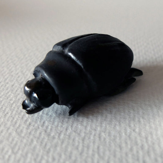 Handcrafted ceramic beetle figurine "The Obsidian Beetle (#2)" in stoneware by Nikolaj Jesper Cyon. Finished with a satin black glaze over a smooth, rounded carapace and sculpted anatomical insect details.
