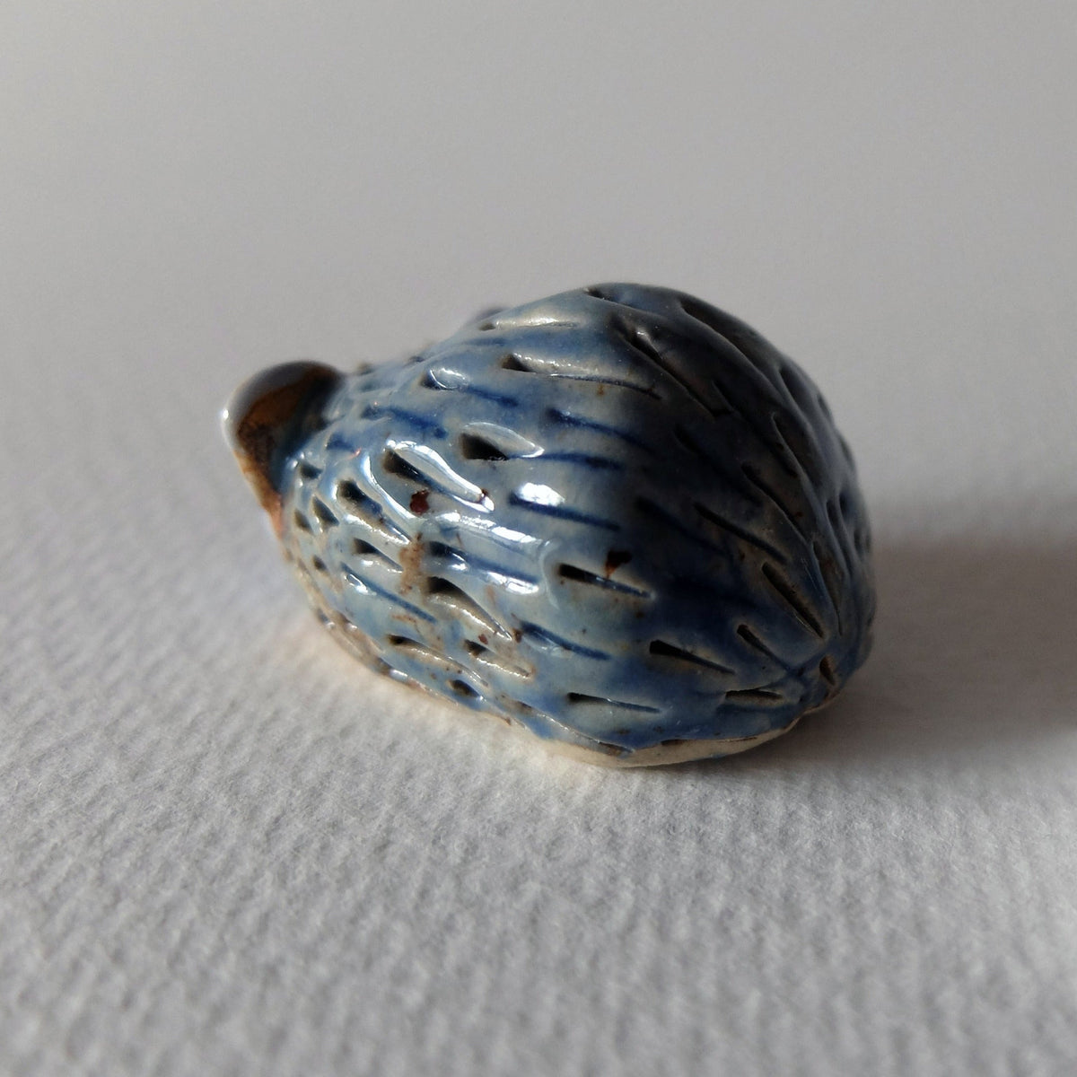 Handcrafted ceramic hedgehog figurine "The Timid Jade-Gazer (#1)" in stoneware by Nikolaj Jesper Cyon. Side profile view.